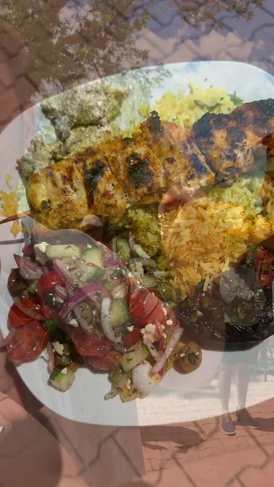 Plated grilled chicken, saffron rice and salad at World Within